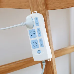 White household power strip extension lead socket holder mounted on wooden furniture leg.