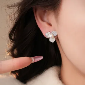 Close-up detail shot of the floral pearl zircon earrings, highlighting delicate mother-of-pearl petals.