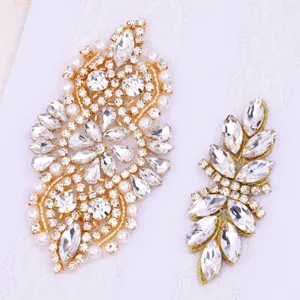 Detailed close-up of sparkling rhinestone and pearl crystal gold applique patches.