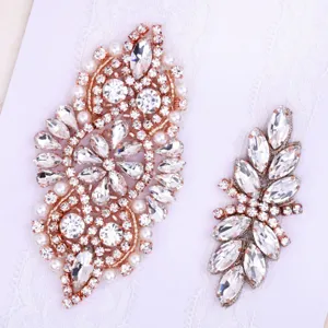 Closeup detail of elegant rose gold rhinestone and pearl bridal garter lace applique.