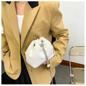 Detail shot of white plush bucket bag with chain strap and pearl charm, soft texture style.
