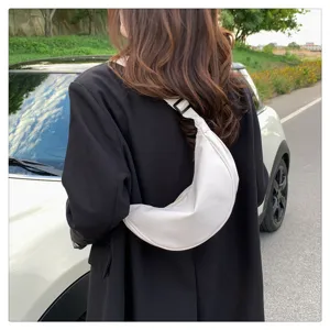 Detailed close-up view of white nylon crescent dumpling shoulder bag worn outdoors.