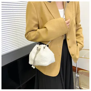 Fluffy plush bucket bag detail showing soft white texture and elegant metal chain strap.