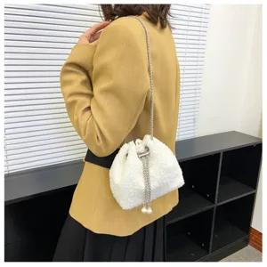 Detail shot of white fluffy bucket bag featuring metal chain strap and pearl decor.