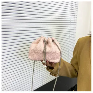 Close-up detail of fluffy pink plush drawstring bucket bag featuring elegant pearl chain strap.