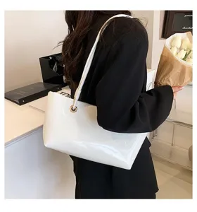 White patent leather tote bag detail view, stylish gloss shoulder bag for women daily commute.