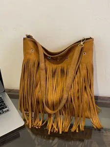 Brown suede fringe shoulder bag detail showing soft texture, metal rings, and large capacity.
