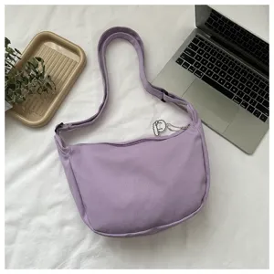 Detail view of purple waffle dumpling shoulder bag, showing textured fabric and zipper.