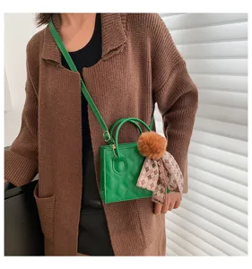 Green quilted crossbody bag with furry pom pom and plaid ribbon, stylish daily handbag.