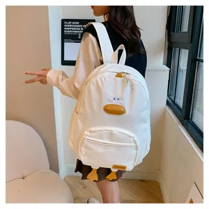 Dettaglio dello zaino bianco a forma di anatra con becco e occhi divertenti per la scuola.