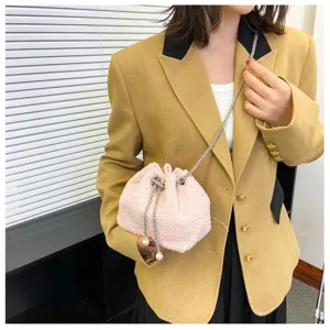 Pink plush bucket bag detail showing soft fuzzy texture, metallic chain strap and pearls.