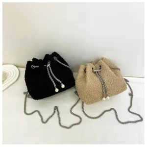 Plush drawstring bucket bag detail displaying soft texture, chain strap, and pearl charms.