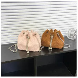 Plush bucket bag detail view showing soft texture, metal chain strap, and cute pearl accents.