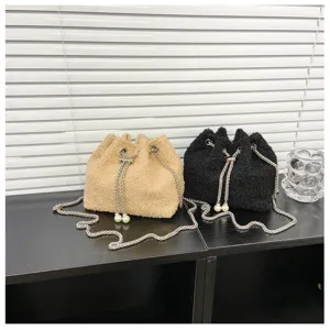 Detailed view of plush bucket bag featuring metal chain strap and elegant pearl drawstring.