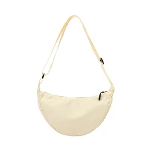Beige nylon crescent dumpling crossbody bag, lightweight casual shoulder bag for daily use.