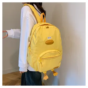 Dettaglio zaino giallo con paperella carina, becco e zampe 3D, stile casual per studenti giovani.