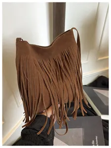 Brown suede fringe shoulder bag close-up, showcasing soft texture and stylish tassel design.