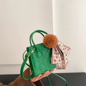 Green quilted small crossbody handbag featuring a fluffy pompom and stylish scarf.