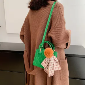 Stylish green quilted crossbody handbag with top handle, cute pom-pom and ribbon charm for women.