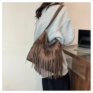 Brown fringe shoulder bag for women, stylish suede crossbody bag with metal eyelets.