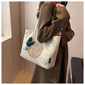 Large capacity canvas tote bag for women, stylish casual shoulder bag with letter patch.