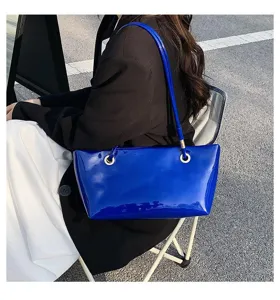 Glossy patent leather shoulder bag detail with vibrant blue finish and chic metal ring accents.