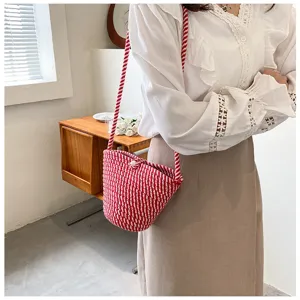 Red white woven bucket bag detail shot, stylish crossbody bag showing texture and design.