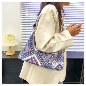 Detailed view of the stylish geometric pattern canvas shoulder bag worn by model.
