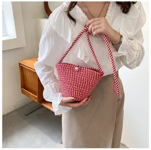 Red and white woven bucket bag detail, stylish rope crossbody bag with pearl closure for women.