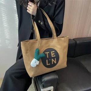Large capacity canvas tote bag for women casual shoulder bag with cute plush pendant.