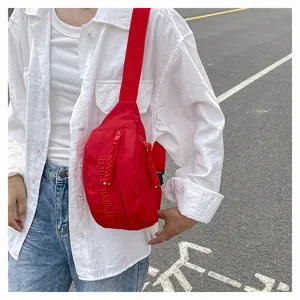 Detail view of the red crossbody chest bag, showcasing zipper pocket and streetwear style.