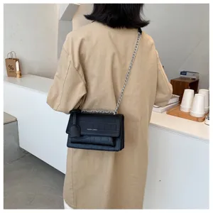 Stylish women's crocodile pattern shoulder bag with chain strap, minimalist casual design.