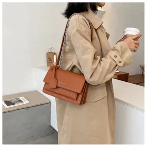 Brown crocodile pattern shoulder bag detail, stylish chain strap and sleek flap design.