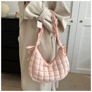 Close-up detail of the pink quilted cloud underarm bag with ruched strap and side bow accent.