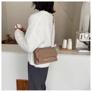 Detailed view of women's stylish crocodile pattern shoulder bag with chain strap and flap.