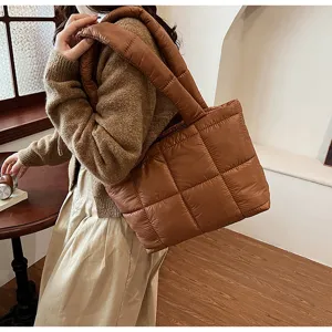 Detailed view of brown quilted puffer tote bag, cozy winter accessory showcasing soft texture.