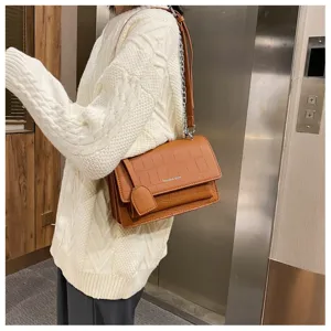 Detail view of brown crocodile pattern shoulder bag with chain strap and elegant style.
