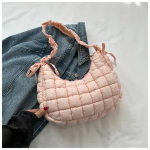 Pink quilted cloud shoulder bag detail, highlighting soft puffed texture and pleated strap.