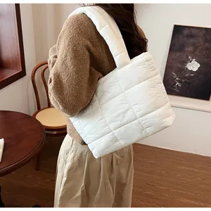 Detailed view of the white quilted puffer shoulder bag showcasing soft texture and wide strap.