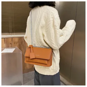 Women stylish brown faux leather crossbody bag with chain strap and elegant crocodile pattern.