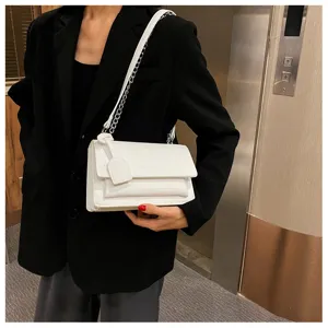 Detailed view of white crocodile pattern shoulder bag with chain strap, chic daily accessory.