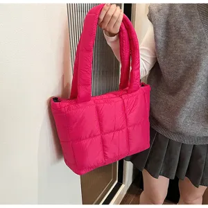 Close-up of hot pink quilted puffer tote bag, stylish grid pattern, soft padded shoulder strap.