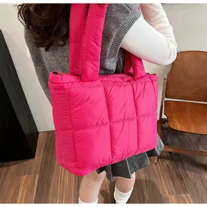 Bright pink quilted puffer tote bag for women, stylish winter padded shoulder handbag.