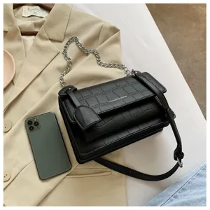 Detailed view of the black crocodile pattern chain shoulder bag in a stylish flat lay setup.