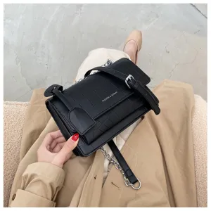 Black crocodile pattern shoulder bag with chain strap, stylish women's crossbody bag detail.