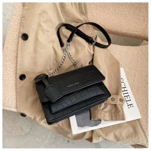 Black crocodile pattern crossbody shoulder bag with chain strap and flap design for women.
