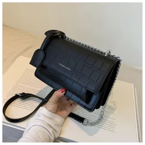 Black stone pattern crossbody bag detail view showing metal chain and texture craftsmanship.