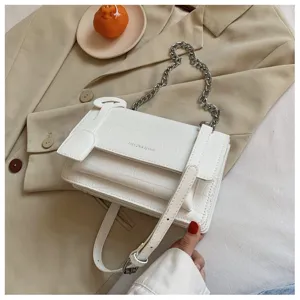 White crocodile pattern crossbody bag detail view featuring chic metal chain strap.