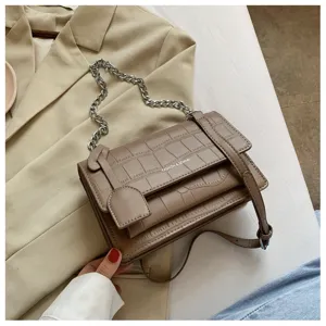 Brown crocodile pattern faux leather shoulder bag with metal chain strap, close-up view.