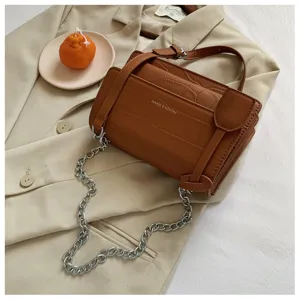 Brown crocodile pattern shoulder bag detail, featuring metallic chain strap and chic design.